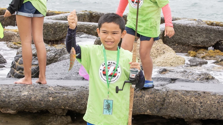 boy holding up fish